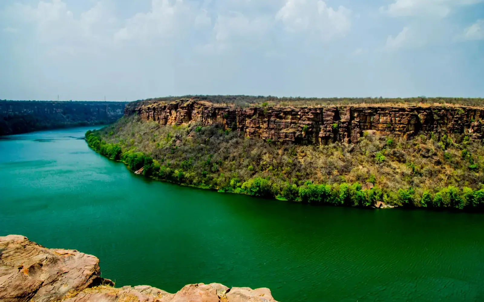 The Chambal river curving through a deep rocky gorge under a blue sky